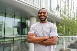 Happy african american man smiling outdoor. Portrait of young happy man on street in city. Cheerful joyful handsome person guy looking at camera. Freedom happiness carefree happy people concept photo