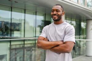 Happy african american man smiling outdoor. Portrait of young happy man on street in city. Cheerful joyful handsome person guy looking at camera. Freedom happiness carefree happy people concept photo