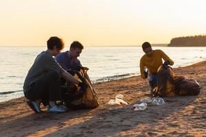 tierra día. voluntarios activistas recoge basura limpieza de playa costero zona. mujer y mans pone el plastico basura en basura bolso en Oceano costa. ambiental conservación costero zona limpieza foto