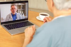 Senior man doctor expert examining older senior woman online. Old woman lady patient and doctor talk on video call have consultation with laptop. Medicine healthcare medical checkup. Online doctor photo