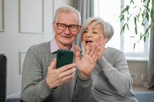 vídeo llamar. contento mayor Pareja mujer hombre con teléfono inteligente teniendo vídeo llamar. maduro antiguo abuela abuelo hablando Hablando en línea. más viejo Generacion moderno tecnología uso. virtual reunión en línea charla foto