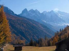 a mountain range with a cabin in the foreground photo