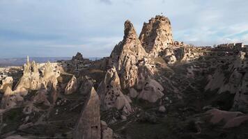 aéreo zumbido ver de el uchisar castillo en capadocia, Turquía durante puesta de sol. esta alto Roca volcanica afloramiento es uno de de capadocia más prominente puntos de referencia video