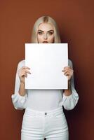 AI generated caucasian woman holding a blank sheet of paper on brown background, neural network generated photorealistic image photo