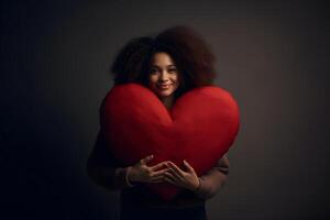 AI generated mixed race woman holding big red heart on gray background, neural network generated photorealistic image photo