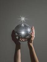 AI generated hands holding a disco ball with a light and stars photo