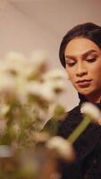 Portrait of a thoughtful woman with flowers in the foreground, creating a dreamy, soft-focus effect. video