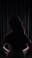 silhouet van een vrouw staand in voorkant van een venster met gordijnen video