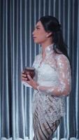 Elegant woman in a lace dress holding a cocktail at a sophisticated event video