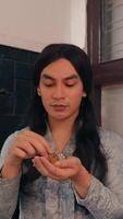 Portrait of a young woman with long hair examining an object in his hands, indoors with soft lighting. video