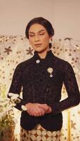 Elegant person in vintage attire posing with floral backdrop video