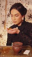 Elegant woman in black dress smelling tea leaves, vintage style video