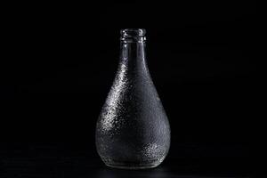 Empty glass bottle isolated on black background. photo