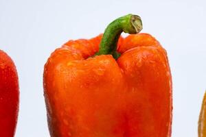 Fresh red bell pepper with water drops isolated on white background. photo