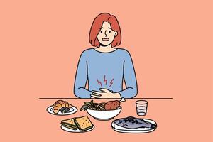 Girl suffers from stomach pain due to digestive problems, sits at dinner table with food vector