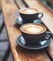 ai generado dos café tazas con latté Arte en parte superior de ellos foto