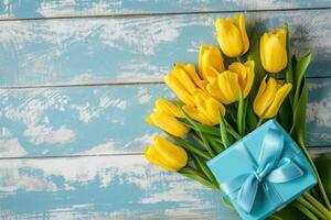 AI generated yellow tulips with blue gift box on blue wooden background photo