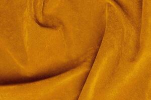 light orange velvet fabric texture used as background. silk color saffron fabric background of soft and smooth textile material. crushed velvet .luxury sun light tone for silk. photo