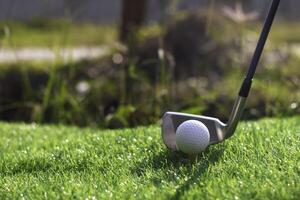 Golf ball close up on tee grass on blurred beautiful landscape of golf background. Concept international sport that rely on precision skills for health relaxation photo