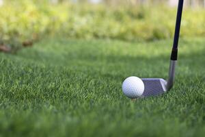 Golf ball close up on tee grass on blurred beautiful landscape of golf background. Concept international sport that rely on precision skills for health relaxation photo