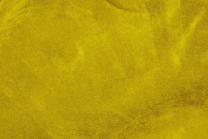 ligero amarillo terciopelo tela textura usado como antecedentes. seda color oro tela antecedentes de suave y suave textil material. aplastada terciopelo .lujo dorado ligero tono para seda. foto