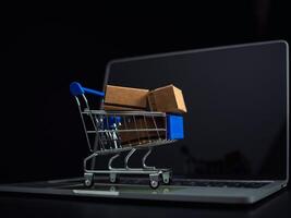 cajas en un compras coche en un ordenador portátil teclado. ideas acerca de en línea compras, en línea compras es un formar de electrónico comercio ese permite consumidores a directamente comprar bienes desde vendedor terminado el Internet. foto