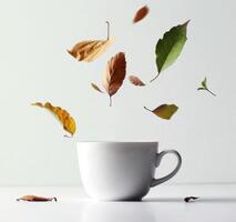 AI generated a white cup with leaves falling from it photo