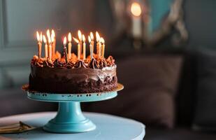 ai generado un chocolate cumpleaños pastel con iluminado velas en eso sentado en un azul estar foto