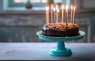 ai generado un chocolate cumpleaños pastel con iluminado velas en eso sentado en un azul estar foto