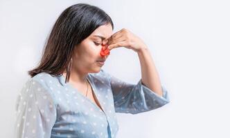 Young woman with pain touching nose. Person with nasal bridge pain, Girl with nasal bridge headache. Sinus pain concept photo