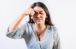 Person with nasal bridge pain, Girl with nasal bridge headache. Sinus pain concept. Young woman with pain touching nose photo