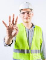 Young engineer counting number four isolated. Male engineer showing number four with fingers isolated photo