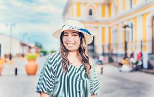 estilo de vida de contento viajero mujer en un turista cuadrado. retrato de sonriente turista niña en el calles de granada, Nicaragua foto