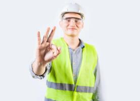 Young engineer counting number three isolated. Male engineer showing number three with fingers isolated photo