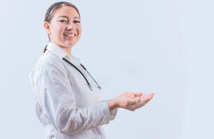 Beautiful smiling female doctor showing an advertisement with palms. Happy female doctor presenting something with palms photo