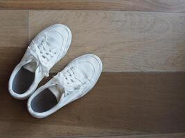 white canvas shoes on green and wooden backgrjound classic style easy and smooth life style photo