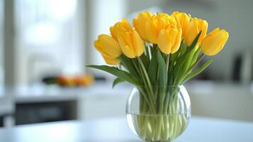 AI generated Yellow tulips stand in a wide glass vase on a white table photo