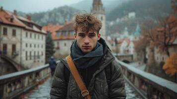 ai generado joven hombre mirando a el cámara mientras en pie en un puente en un antiguo europeo pueblo foto