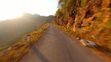 fpv voar sobre montanha estrada em a ha giang ciclo às pôr do sol, norte Vietnã video