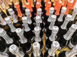 many bottles of champagne in a grocery store closeup with selective focus and wide angle photo