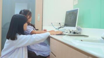 mujer dentista explicando la radiografía de los dientes a una niña en la clínica dental, chequeo dental y concepto de dientes sanos video