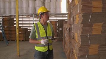 Portrait of asian engineer man order details checking goods and cardboard box with goods background in warehouse.logistic and business export.Product Distribution Logistics Center. video