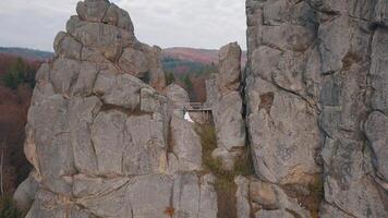 Newlyweds stand on a high slope of the mountain. Groom and bride. Arial view video