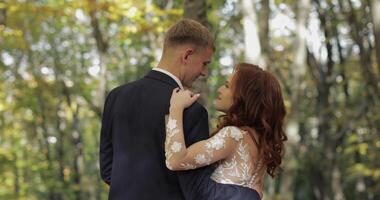 jeune marié avec la mariée dans le forêt parc. mariage couple. fabrication une baiser video