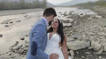 Boda Pareja en pie cerca montaña río. novio y novia en amor video