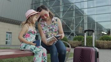 Mother and daughter near airport. Woman hold passports and tickets in hand. Child and mom vacation video