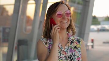 Mädchen tragen modisch Sonnenbrille Verwendet ihr Telefon. mit Smartphone zum Forderung, sprechen. Urlaube, Tourismus video
