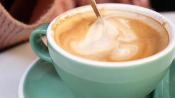 person hand stirring coffee with spoon. video