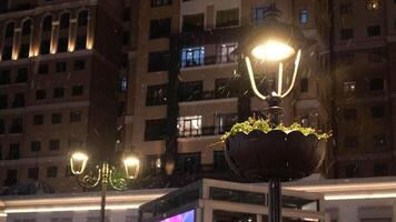 low angle view of Snowfall and buildings on background at night video