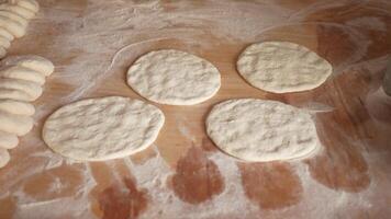 the chef's hands form a round pizza base from the dough with his hands. video